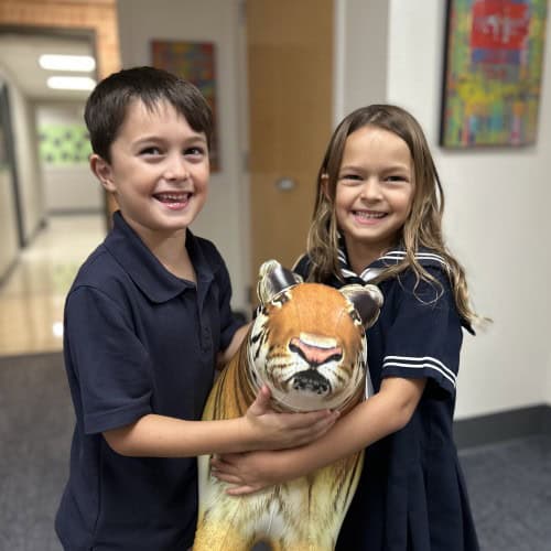Siblings holding a Tiger