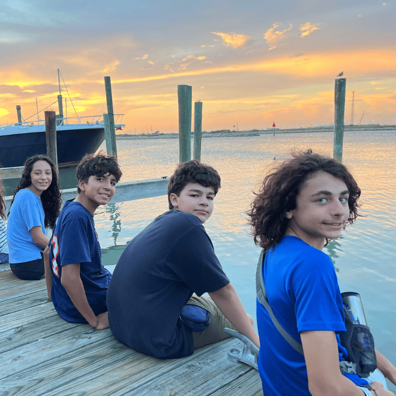 Signature Programs - 8th Grade Year Students sitting on a dock