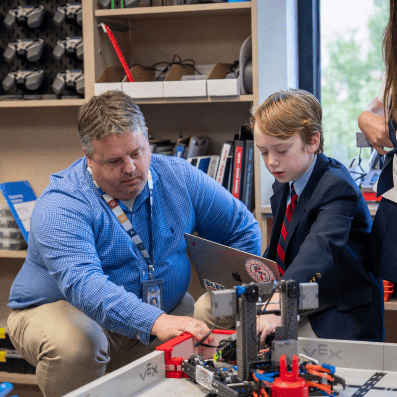 Stem & Robotics Student & Teacher working on a robot